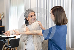 asian senior woman doing physiotherapy that support from a young female nurse