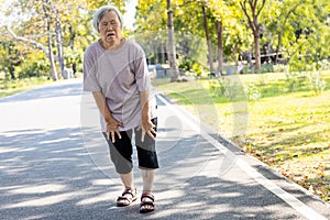 Asian senior woman is extremely tired while walking at park, body is weak feeling tired easily due to lack of energy and donÃ¢â¬â¢t photo
