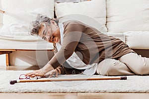 Asian senior woman falling down lying on floor at home alone. Elderly woman pain and hurt from osteoporosis sickness or heart