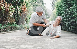 Asian senior woman falling down on lying floor at home after Stumbled at the doorstep and Crying in pain and her husband came to