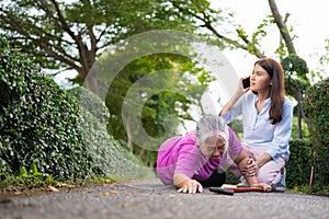 Asian senior woman fell down on lying floor because faint and limb weakness and pain from accident and woman came to help support