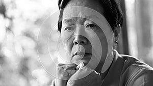 Asian senior woman with hand on face thinking, worry sad