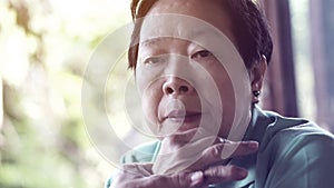 Asian senior woman with hand on face thinking, worry sad