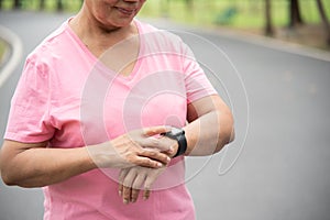 Asian senior woman hands checking his heartbeat with smart watch