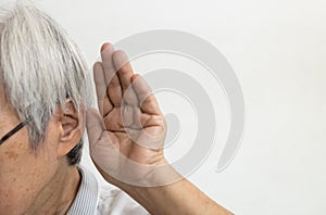 Asian senior woman having impaired hearing,deaf,ear disease,old elderly people trying to listening with hand over her ear,trouble