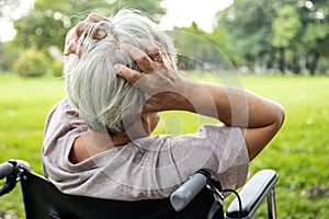 Asian senior woman holding her painful head, brain cancer,hemorrhagic stroke and tumor inside brain,female elderly people with a photo