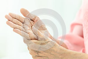 Asian senior woman is massaging her own hand,Elderly woman suffering from pain in hand,arthritis,beriberi