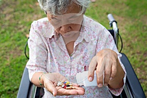 Asian senior woman medicine pills or capsules in hand,sick female patient taking,eating vitamin,antibiotic,painkiller,nutritional