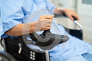 Asian senior woman patient on electric wheelchair with remote control at hospital, healthy strong medical concept