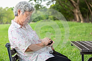 Asian senior woman sit asleep,snooze on chair,elderly female closed her eyes,resting in summer green nature,old people feeling photo