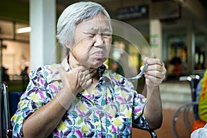 Asian senior woman suffers from choke,clogged up food,elderly people choking during feeding,food might stuck in the throat and