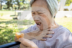 Asian senior woman suffers from choke and cough,clogged up food,elderly people choking during feeding,food might stuck in the