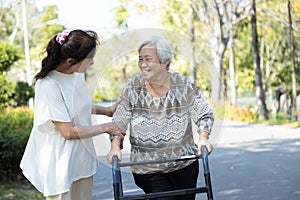 Asian senior woman use walking aid during rehabilitation,elderly people encourage,assisting,care,support her best friend practice