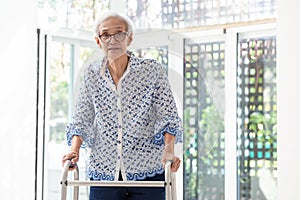 Asian senior woman using walker during rehabilitation, elderly woman with walking and exercising at home