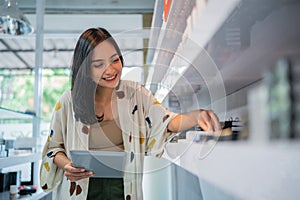 asian shopkeeper smiling while arranging the vape mods stock