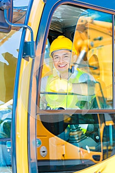 Asian shovel excavator driver on construction site