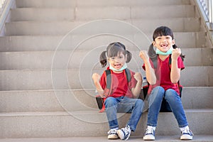 Asian sibling with face mask going back to school after covid-19 quarantine and lockdown