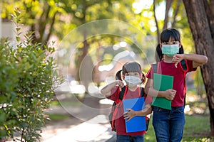 Asian sibling with face mask going back to school after covid-19 quarantine and lockdown