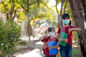 Asian sibling with face mask going back to school after covid-19 quarantine and lockdown