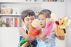 Asian sibling playing hand puppet