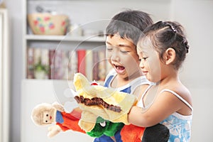 Asian sibling playing hand puppet