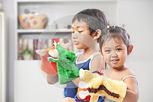 Asian sibling playing hand puppet