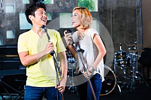 Asian singer producing song in recording studio