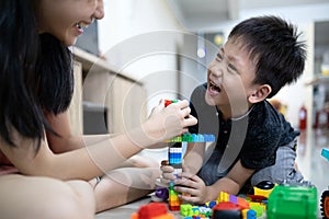 Asian sister is helping the parent to take care of her little brother and playing toys together at home,happy kid boy and child