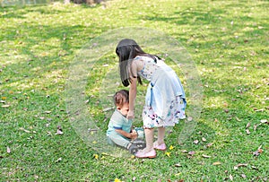 Asian sister take care her little brother in the garden outdoor