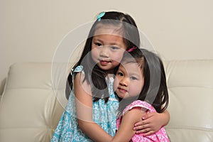 Asian sisters hugging and smiling