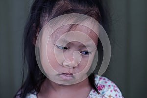 Asian small girl pucker up her mouth feel upset or dissatisfied head shot studio portrait on beige background, concept of naughty