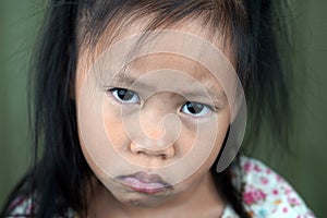 Asian small girl pucker up her mouth feel upset or dissatisfied head shot studio portrait on beige background, concept of naughty photo