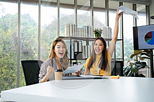 Asian smart Office or businesswoman excited successful business people, celebrating win. Two businesswoman looking at a monthly