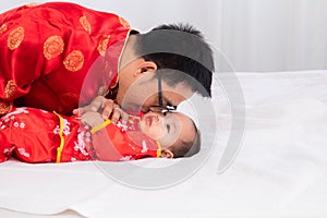 Asian smart young father feed his adorable son baby in bed  healthy fatherhood happy play with infant while feeding both father