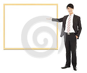 Asian smiling business man pointing blank board