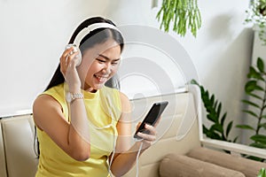 Asian smiling girl student wear wireless headphone study online with skype teacher in a coffee shop, woman learn language listen