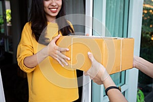 Asian smiling women hand accepting a delivery of parcel boxes from delivery man indoors,Delivery concept