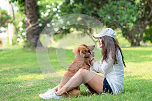 Asian smilling lifestyle woman playing and happy with golden retriever friendship dog in sunrise