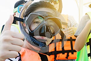 an asian snorkeling girl with mask on speed boat, ready for snorkeling