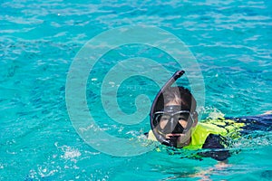 asian snorkeling girl with mask swiming on the se