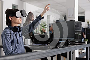 Asian software developer using virtual reality goggles to code new server interfac