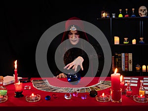 Asian soothsayer woman use blue crystal ball and reading tarot cards for predict future life about love, luck, work, money and