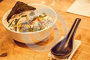 Asian soup with coconut milk and vegetables with spices. Tom yam style dish, typical in Thailand. Thai food with spoon