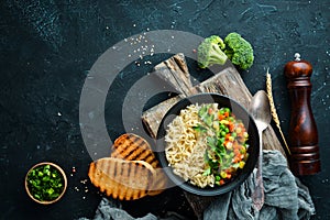 Asian soup with noodles and vegetables in a bowl, with toast bread. Dietary food. Top view.