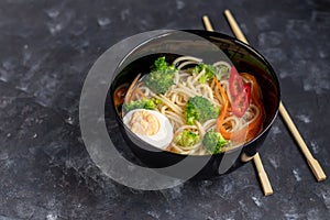 Asian soup with wheat noodles, slices of meat, red chili peppers.