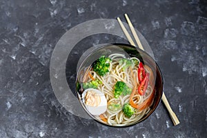 Asian soup with wheat noodles, slices of meat, red chili peppers.
