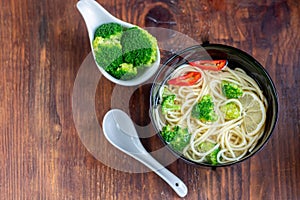 Asian soup with wheat noodles, slices of meat, red chili peppers.