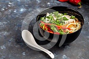 Asian soup with wheat noodles, slices of meat, red chili peppers.