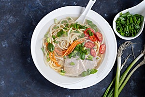 Asian soup with wheat noodles, slices of meat, red chili peppers.