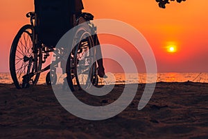 Wheelchair on the sea beach with sunset on travel time in holiday family and learning about nature around the sea